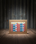 Brown birthday card with a pattern of red, white and blue candles on a wooden surface with a dark background 