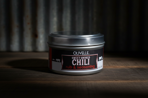 Jar of Olivelle Sweet Smoked Chili Rub & Seasoning on a wooden surface with a dark background