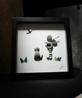 Framed artwork of stone figures on a white background
