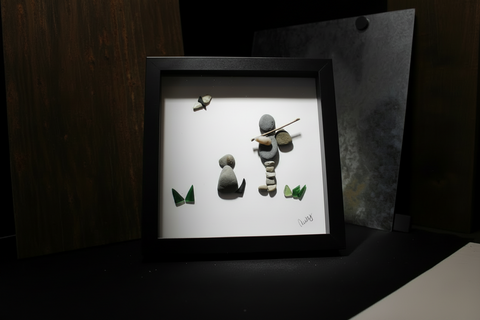 Framed artwork of stone figures on a white background