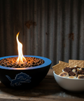 Concrete Detroit Lions bowl with flames and a bowl of s'mores on a wooden surface.