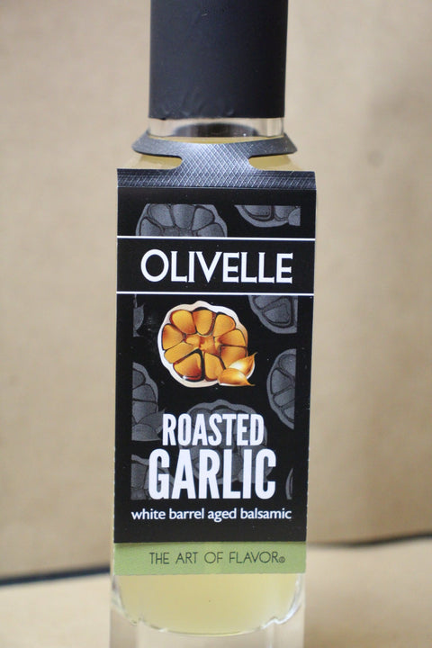 Olivelle roasted garlic balsamic vinegar bottle with label on a beige background