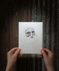 Hands holding a card with a printed face design against a dark wood and metal background