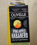 Bottle of Olivelle Pineapple Habanero white barrel aged balsamic on a beige background