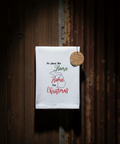 White towel with text hanging on a wooden wall
