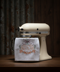Vintage stand mixer with a decorative towel on a wooden surface and rustic background