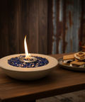 Fire pit bowl with flames on a wooden table, surrounded by pumpkins and gourds.