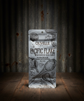 Olivelle Pacific Flake Kosher Sea Salt packaging on a rustic wooden surface with corrugated metal background