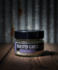 Jar of roasted garlic infused sea salt on a wooden surface with a rustic background
