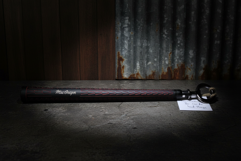 Dark wooden umbrella handle with 'MacGregor' branding on a rustic background
