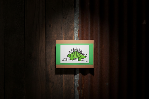 Hand-drawn illustration of a green dinosaur with party hats on a wooden board against a dark wooden background.