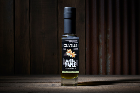 Bottle of Olivelle Vanilla Maple infused olive oil on a wooden surface with a dark background