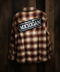 Plaid shirt with 'Made in Michigan' patch on a wooden background