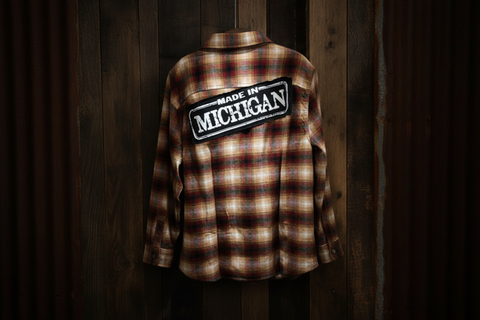 Plaid shirt with 'Made in Michigan' patch on a wooden background