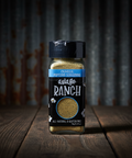 Shaker of asiago ranch seasoning on a wooden surface with a dark background