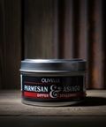 Can of Olivelle Parmesan & Asiago Dipper Seasoning on a wooden surface with a dark background