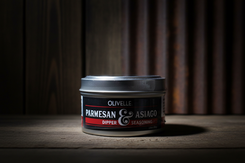 Can of Olivelle Parmesan & Asiago Dipper Seasoning on a wooden surface with a dark background