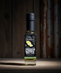 Bottle of Olivelle Sweet Cream Butter on a wooden surface with a rustic background