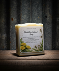 Bar of soap with a label on a wooden surface against a rustic metal background