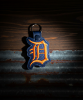 Keychain with a logo on a dark, textured background