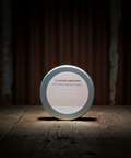 Round product container with 'Almuth Bee Farm' label on a wooden surface