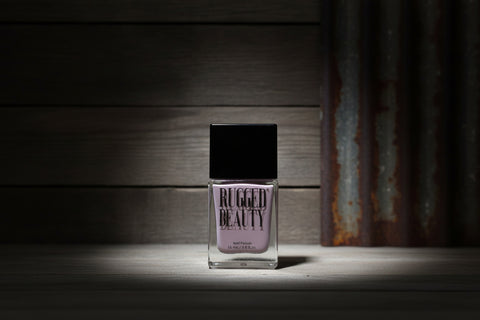 Rugged Beauty nail polish bottle on a wooden surface with a rustic background